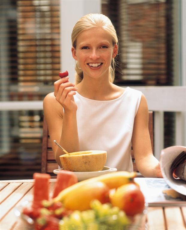 picture of woman eating fruit to fight osteoporosis