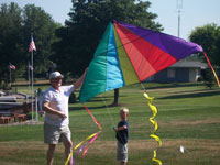 Minster back pain free grandpa and grandson playing with a kite